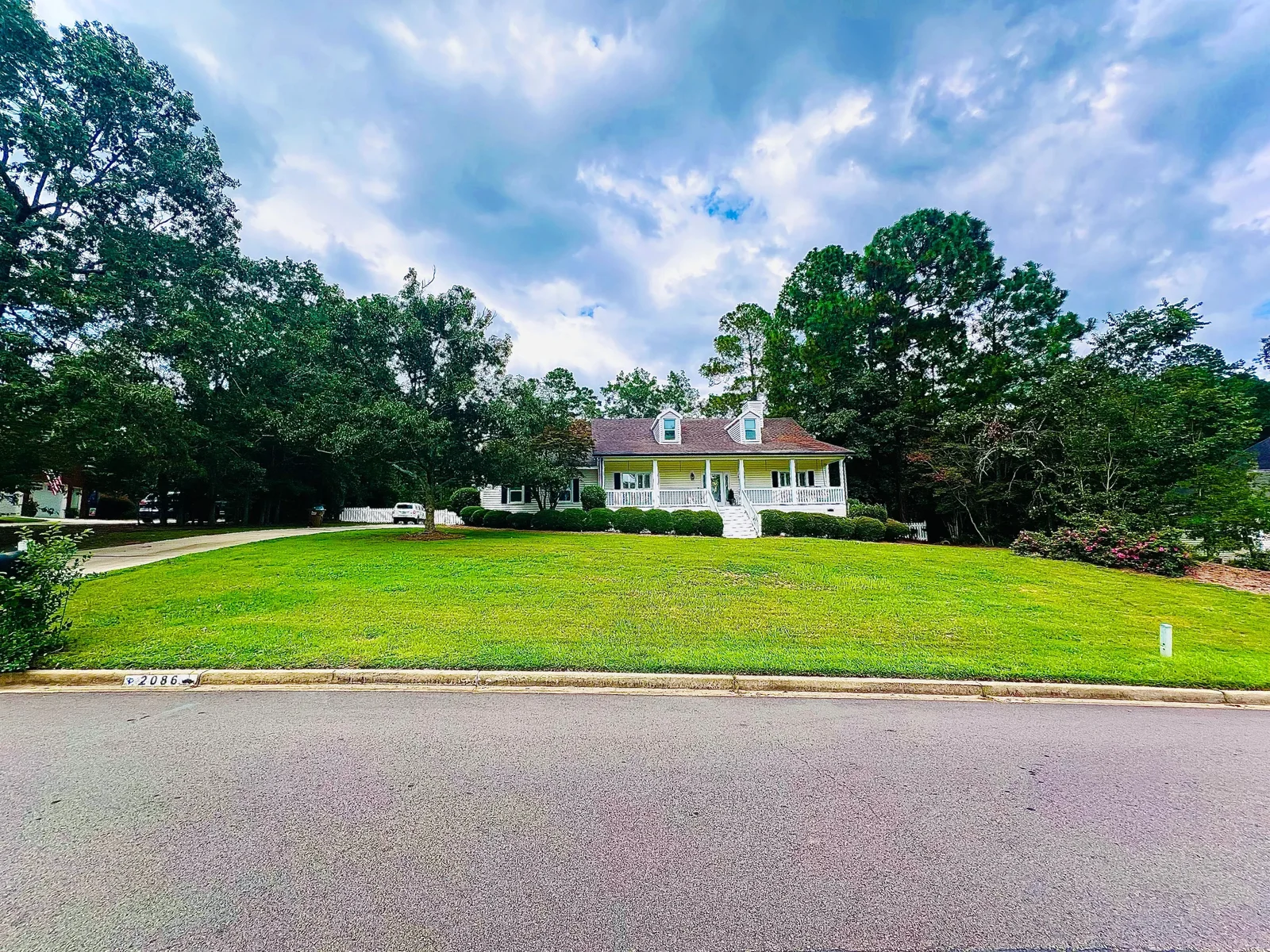 A freshly installed residential lawn in Aiken, SC showing uniform green grass across a graded front yard. The surrounding landscape reflects the sandy soil and warm-season turf typical of the SC Midlands region.